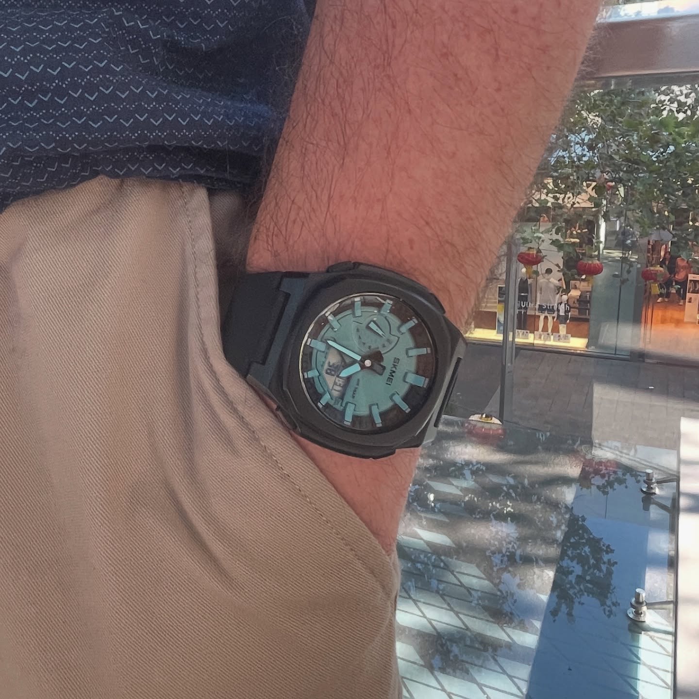 Black and aqua SKMEI 2091 worn on wrist in an urban setting