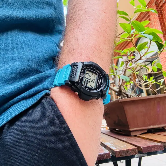 Bright-blue Casio W-219H worn casually on wrist